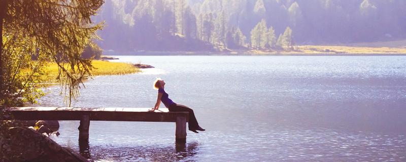person sitting on a dock overlooking the water