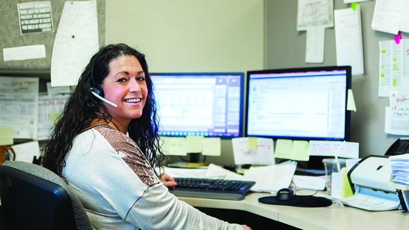 SPH Careers - Employee at desk smiling