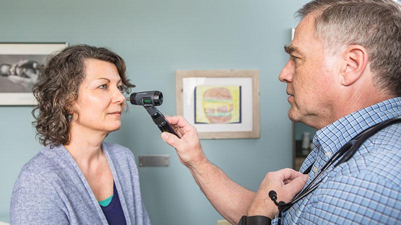 SPH family medicine provider checking patient's eyes